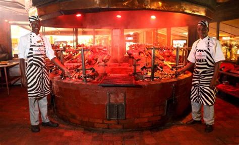 Around 7pm at Nairobi's open-air Carnivore restaurant for a Welcome or farewell Dinner. Kenya's famous nyama choma (barbecued meat) is served on an all-you-can- ...